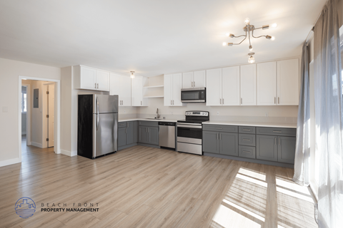A kitchen with wooden floors and white walls.