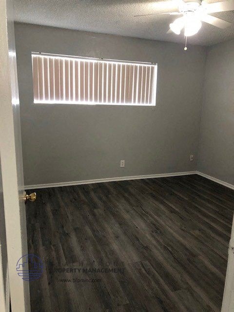 an empty room with wood floors and a window
