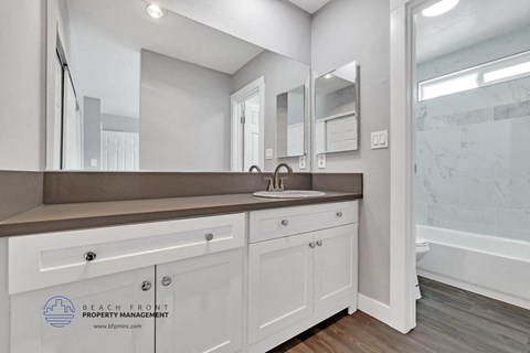 a white bathroom with a sink and a mirror