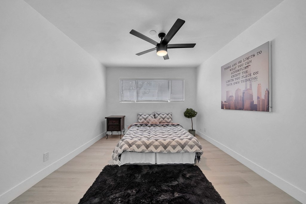 a bedroom with a large bed and a ceiling fan