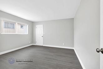 a bedroom with hardwood floors and grey walls