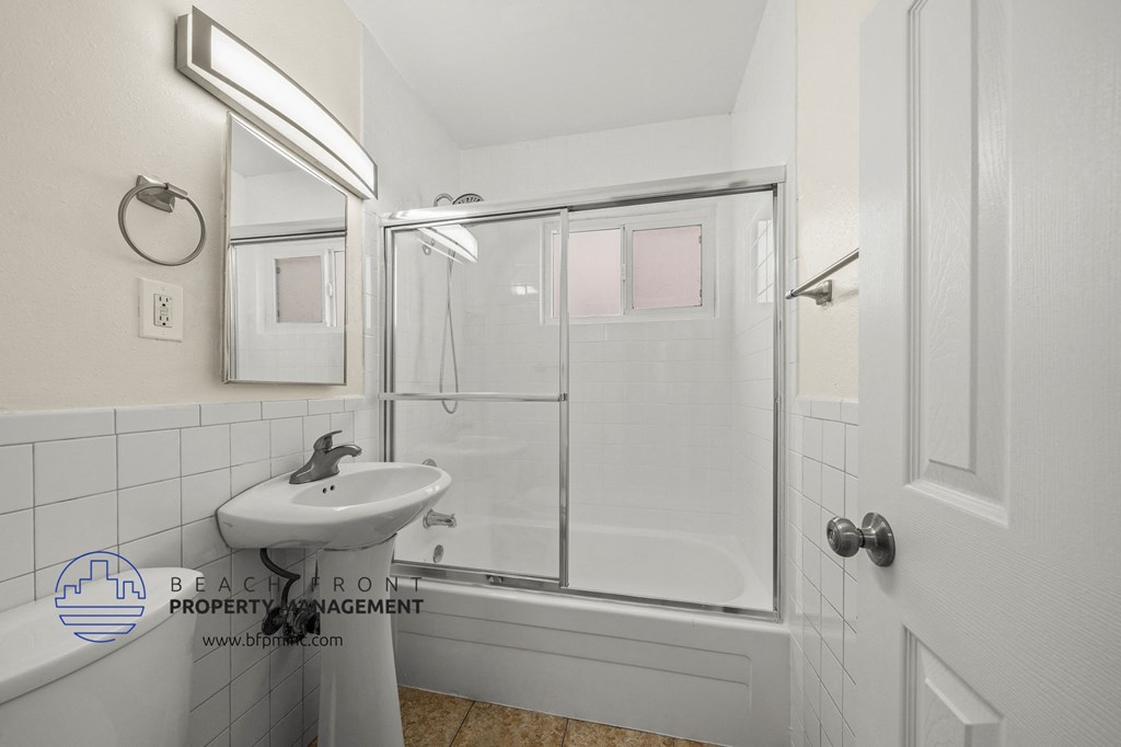 a white bathroom with a sink and a shower