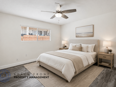 A bedroom with a large bed, a ceiling fan, and a window with blinds.