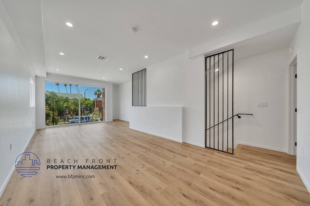 an empty living room with white walls and wood flooring