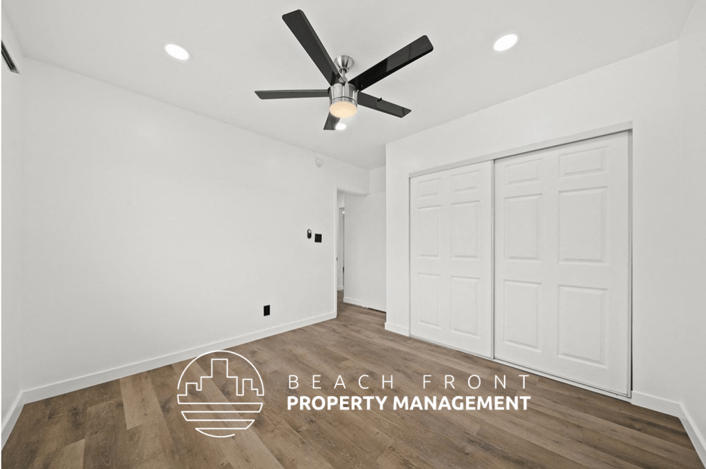 a white room with a ceiling fan and white doors