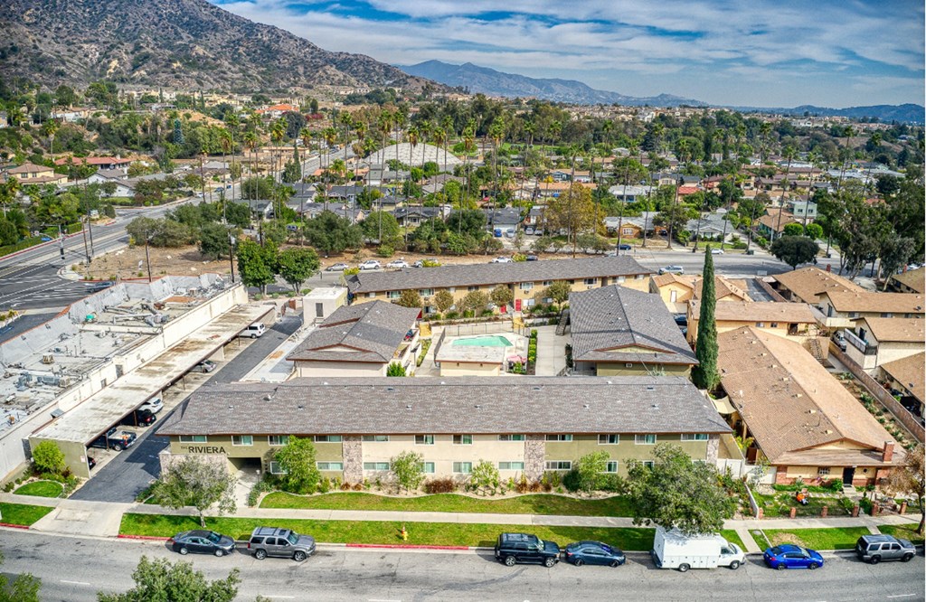 an aerial view of a building with cars parked in a parking lot
