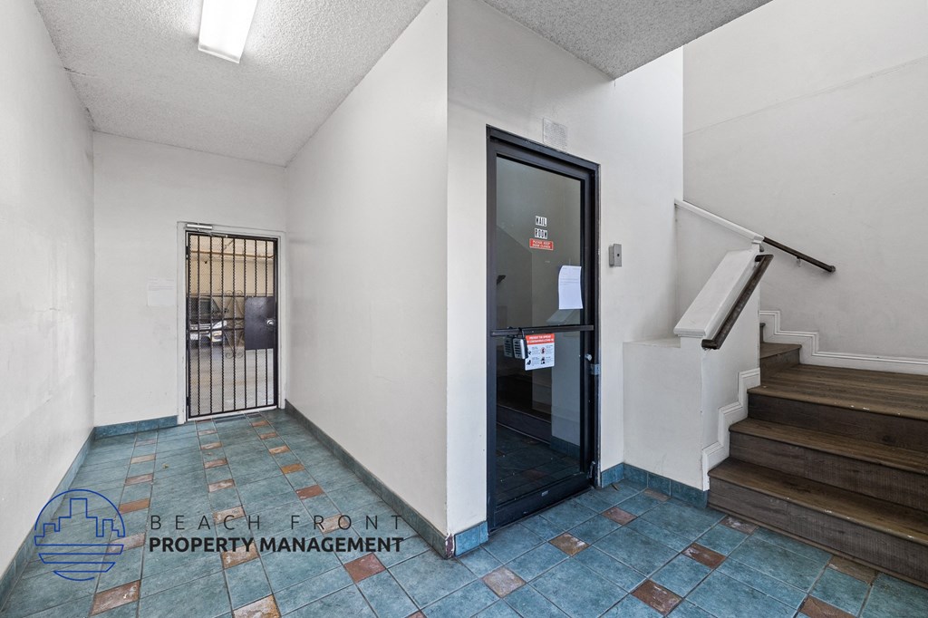 the entrance to the lobby of a building with stairs and a glass door