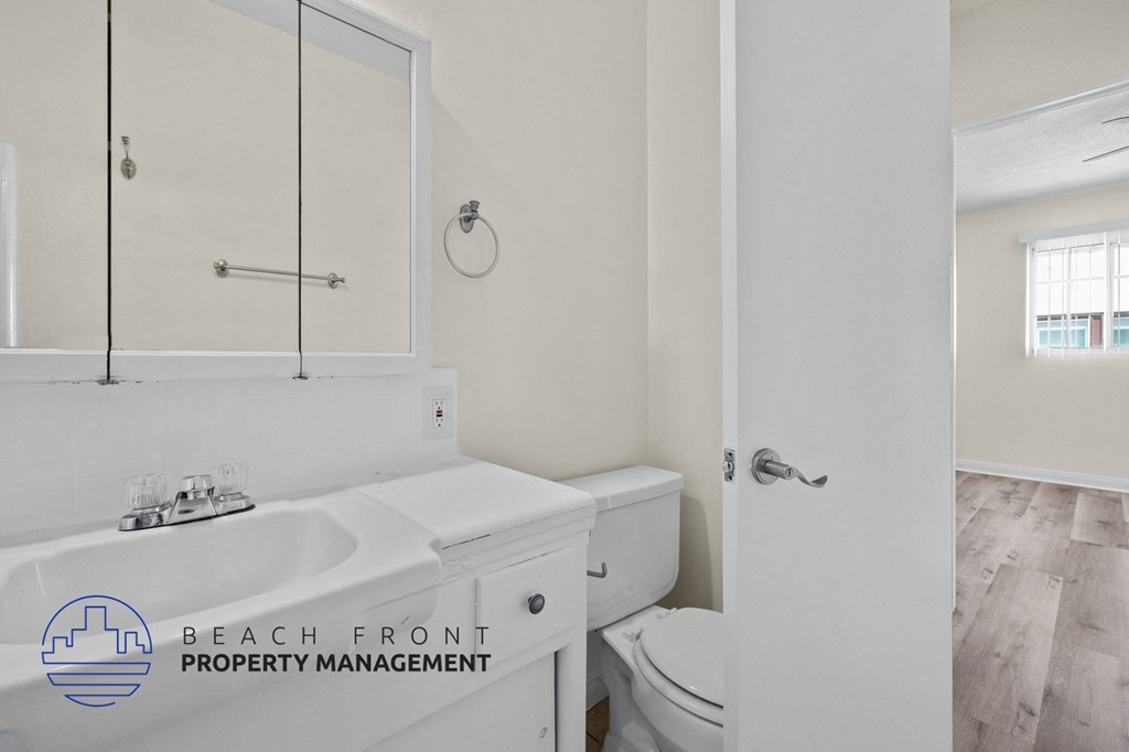 a white bathroom with a sink and a toilet