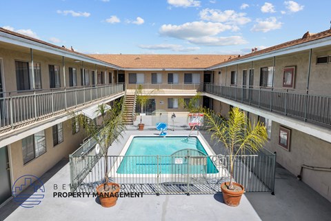 A pool in a courtyard surrounded by buildings.
