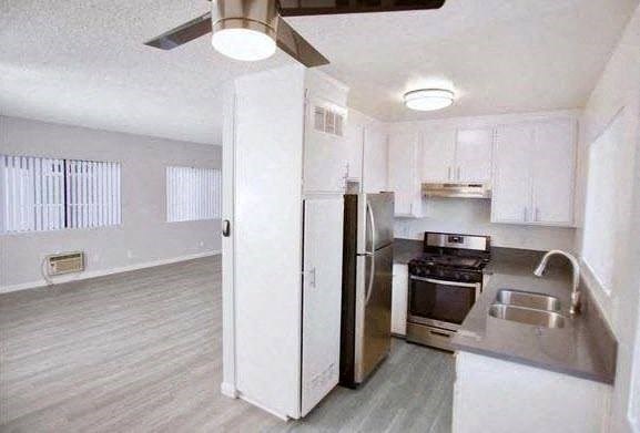 an empty kitchen with a stove and a refrigerator