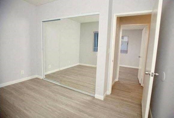 a empty room with a mirror and a wooden floor