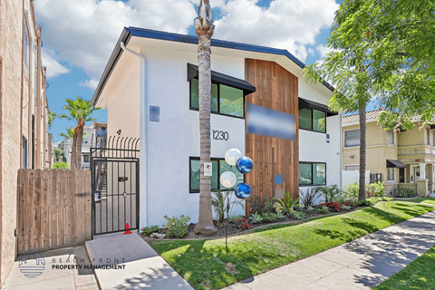 A modern house with a white and brown exterior and a black gate.