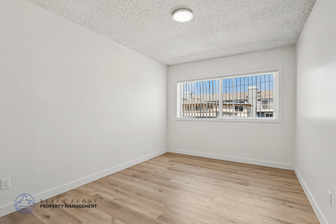 A room with a window overlooking a building.