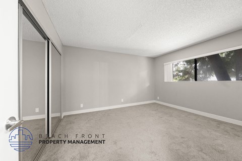 the spacious living room of a manufactured home with carpet and a large window