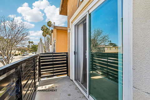 A balcony with a glass door and a metal railing.