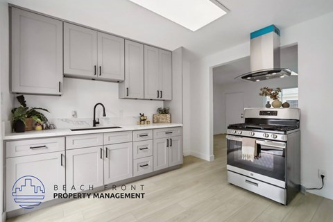 A modern kitchen with a stainless steel oven and white cabinets.
