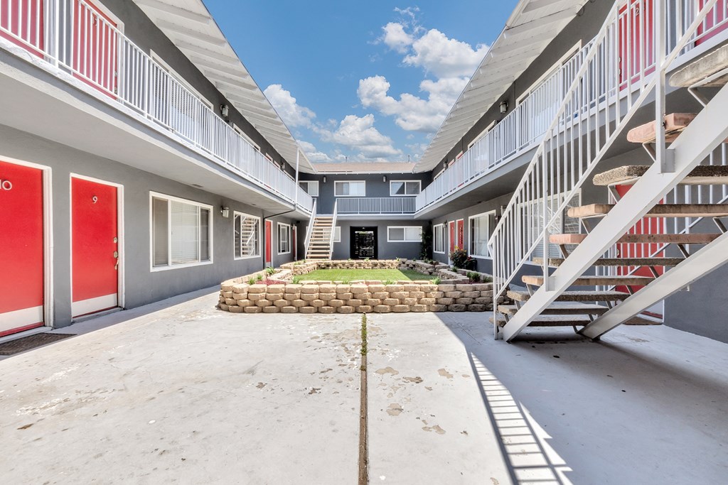 a courtyard with a fountain in the middle of two apartment buildings