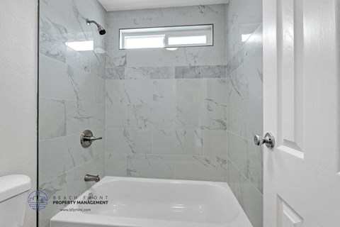 a white bathroom with a shower and a sink