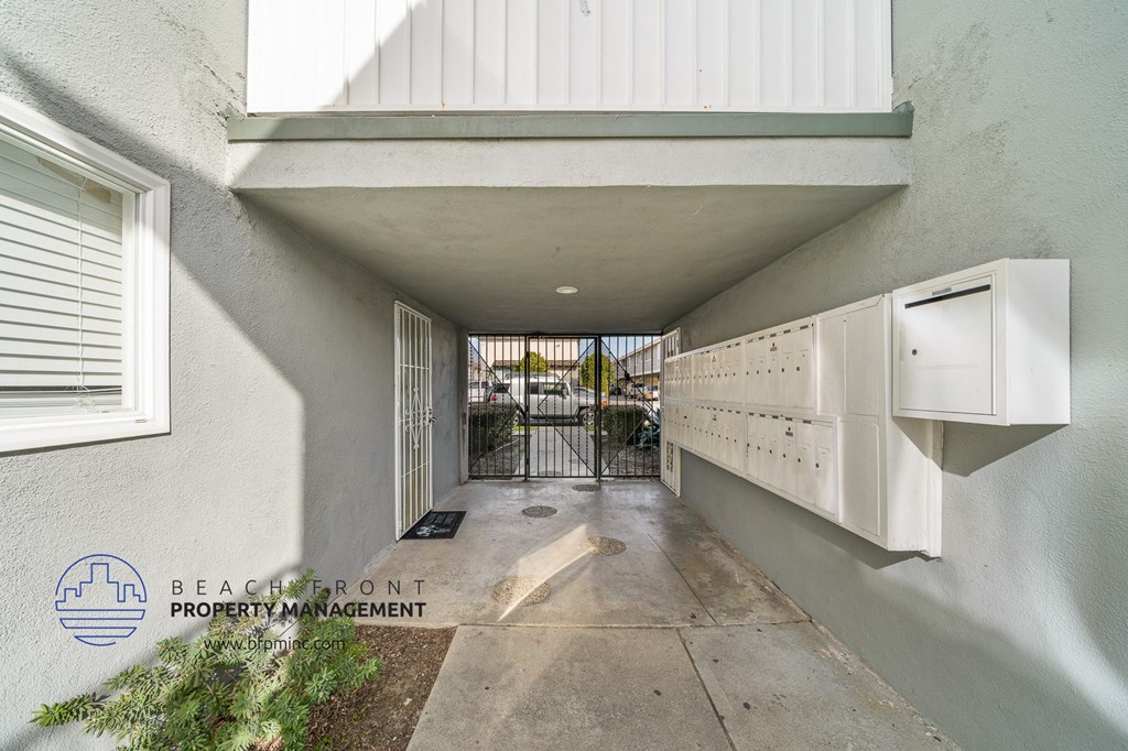 a long hallway with white cabinets on the side of a building