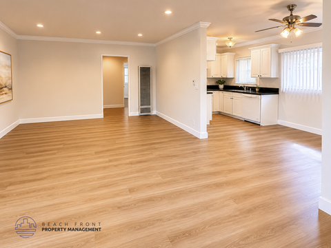 A spacious room with wooden flooring and a ceiling fan.