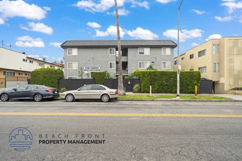 A street view with cars parked and a building with the sign