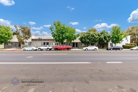 a city street with cars parked in front of an apartment building