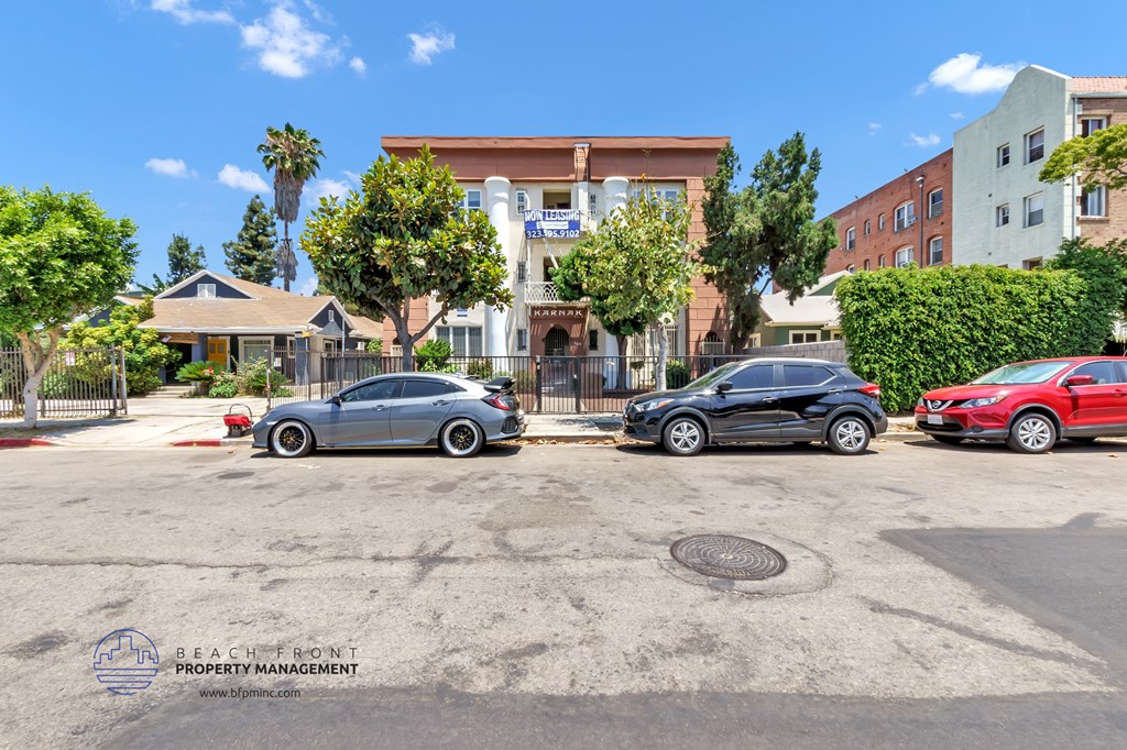 a parking lot in front of a building with cars parked in front