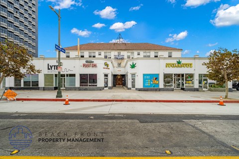 the facade of the beach front property management building with a street in front of it