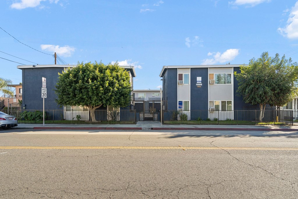 a blue and white apartment building on the side of a street