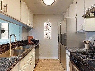A kitchen with a stove top oven and a refrigerator.