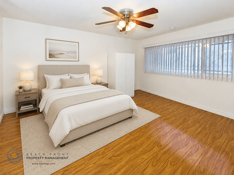 A bedroom with a large bed and a ceiling fan.