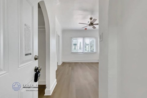A white door with a keypad lock is on the left and a fan is on the ceiling.