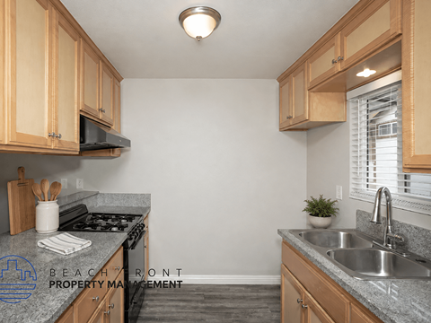 A kitchen with granite countertops and wooden cabinets.