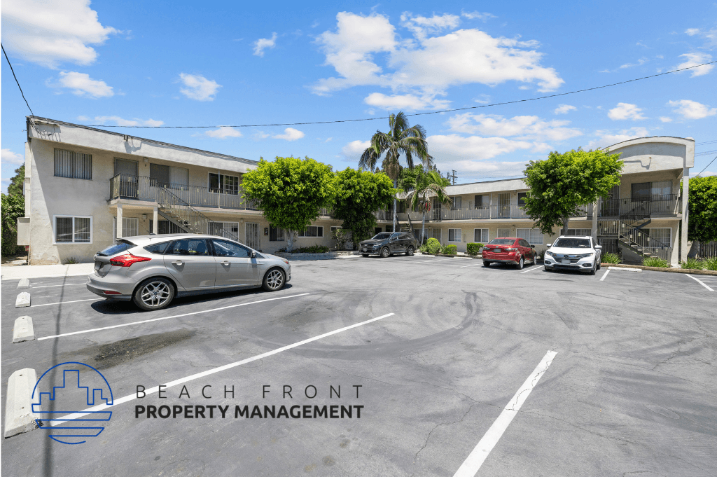 a parking lot in front of an apartment building with cars parked in front