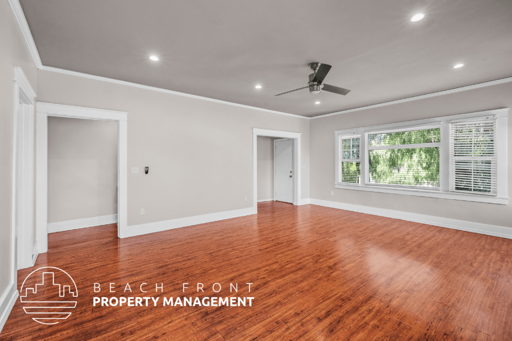 a renovated living room with wood floors and a ceiling fan