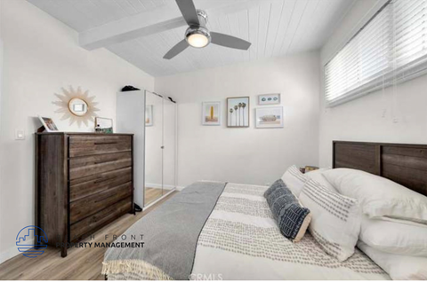 a bedroom with a bed and a ceiling fan