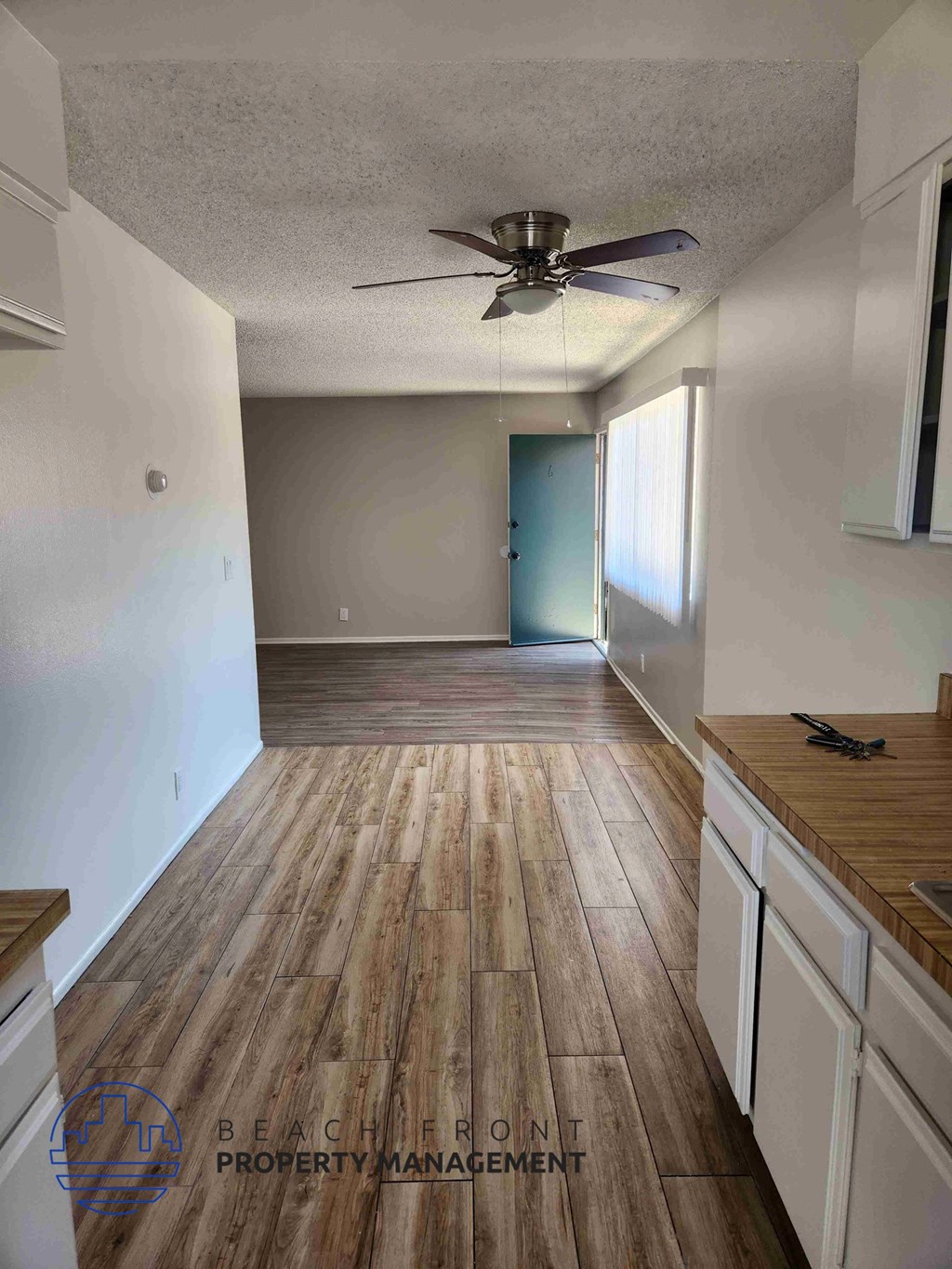 A kitchen with wooden floors and white cabinets.