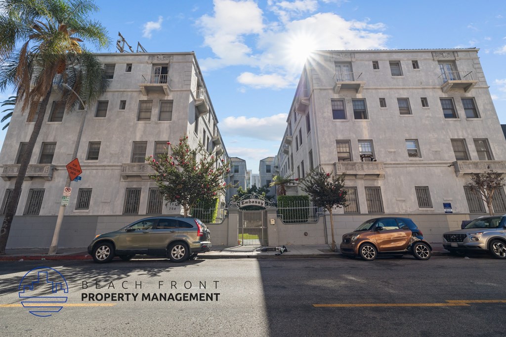 a city street with cars parked in front of two tall buildings