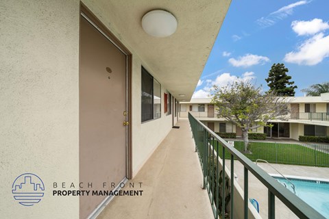 A balcony with a pool and a building in the background.