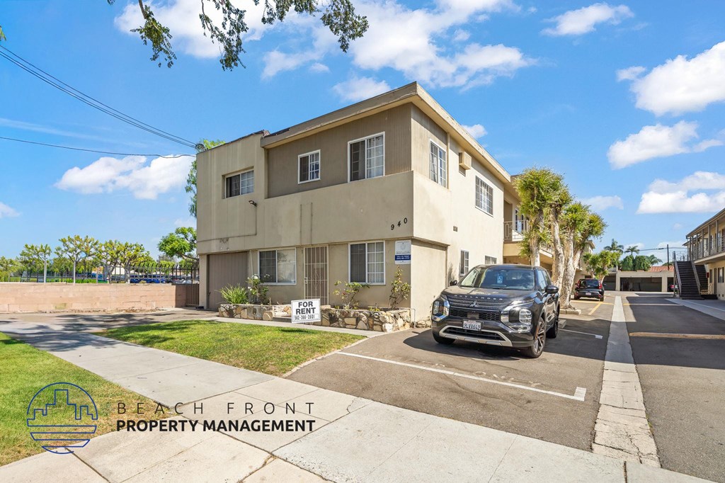 A two-story building with a sign that says "BEACH FRONT PROPERTY MANAGEMENT" in front of it.