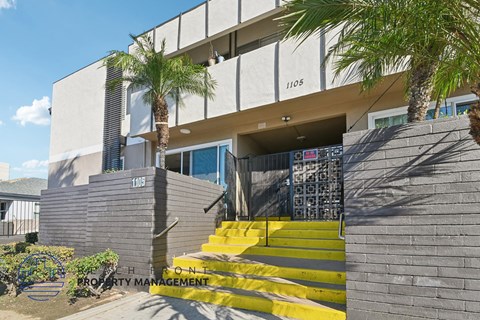 A modern building with a yellow staircase leading to the entrance.