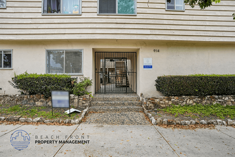 A building with a gate and a sign that says Beach Front Property Management.