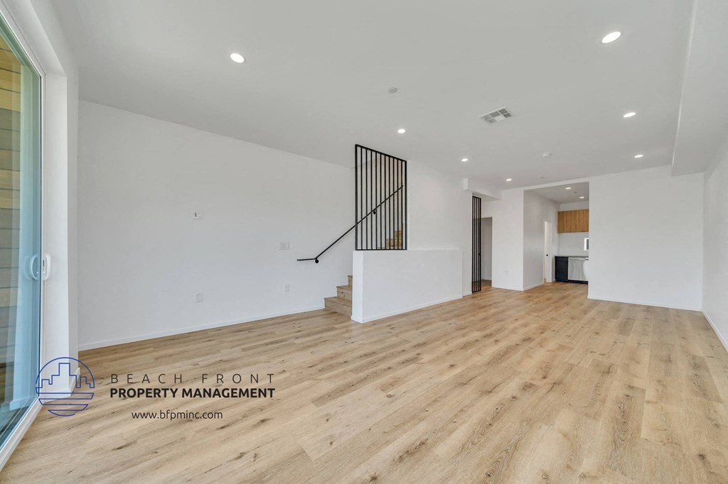 a renovated living room with hardwood flooring and white walls