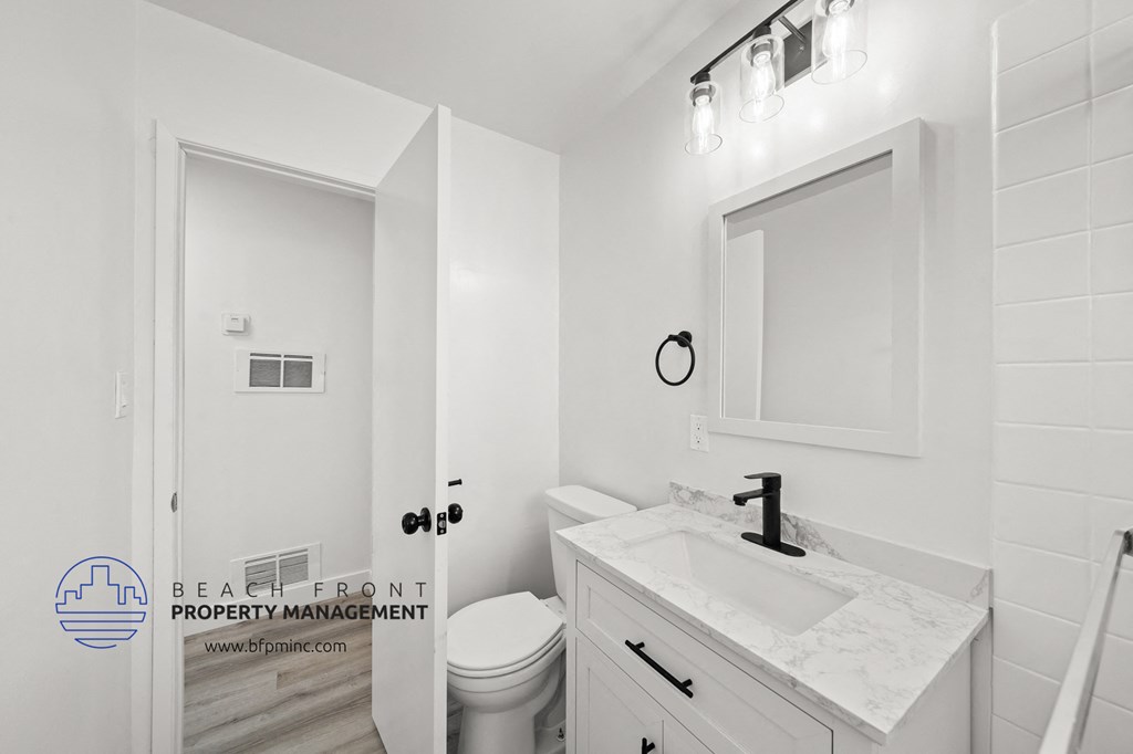 a bathroom with a white sink and toilet and a white door with a glass door