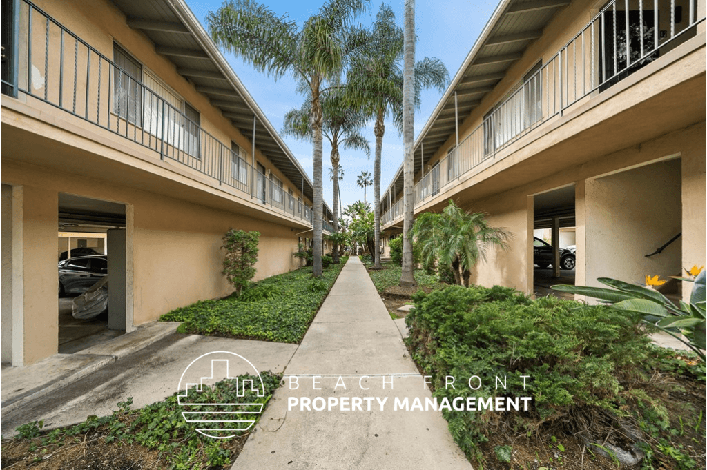 a walkway between two buildings with palm trees