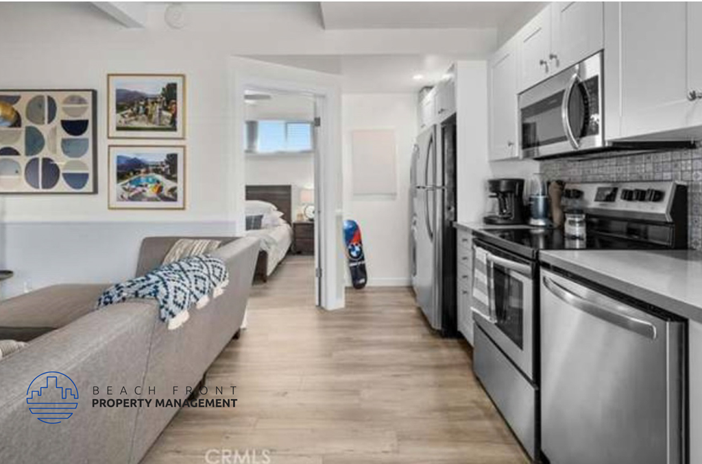 a kitchen with stainless steel appliances and a living room