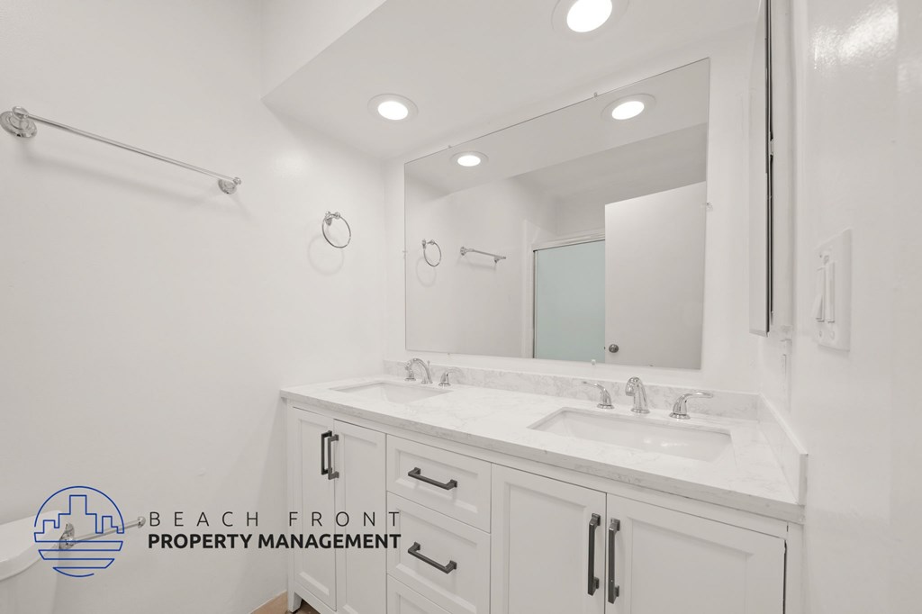 A bathroom with a white sink and a mirror.