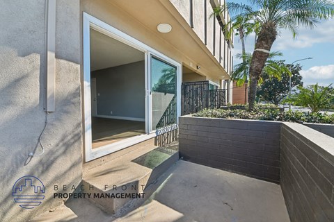 A modern house with a glass door and a palm tree in the background.