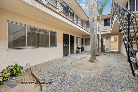 A courtyard with a tree and a small fountain in the middle.