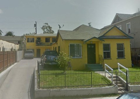 a yellow house with a car parked in front of it